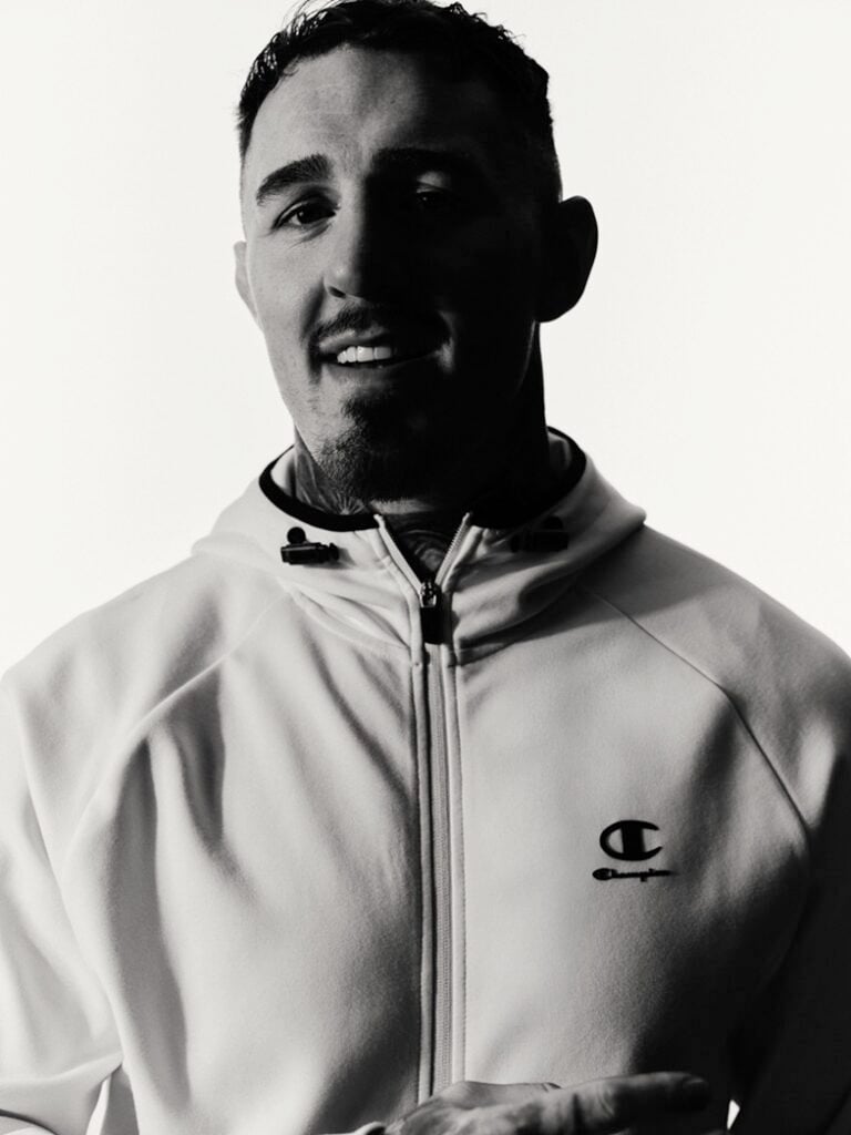 Tom Aspinall smiling at the camera for Champion