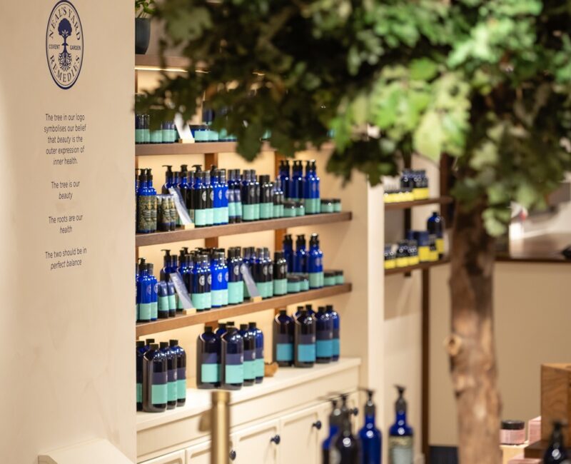 Internal Store Image of Neal’s Yard Remedies showing shelves of products in blue bottles.